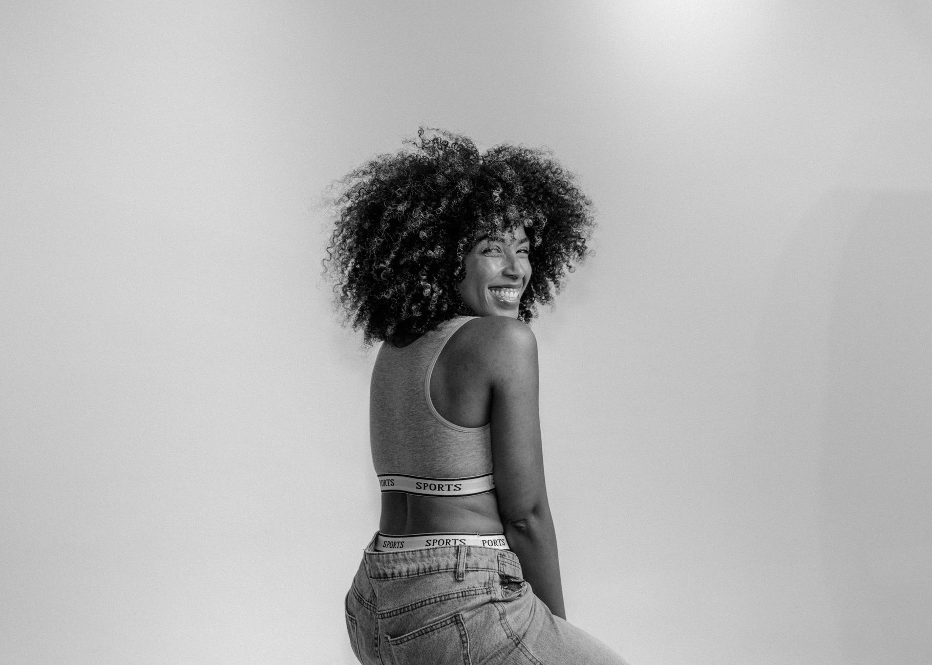 smiling woman in sportswear with stylish afro hair
