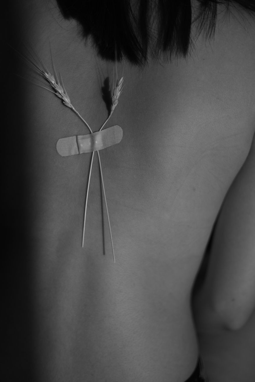 close up of two pieces of wheat taped to a womans back